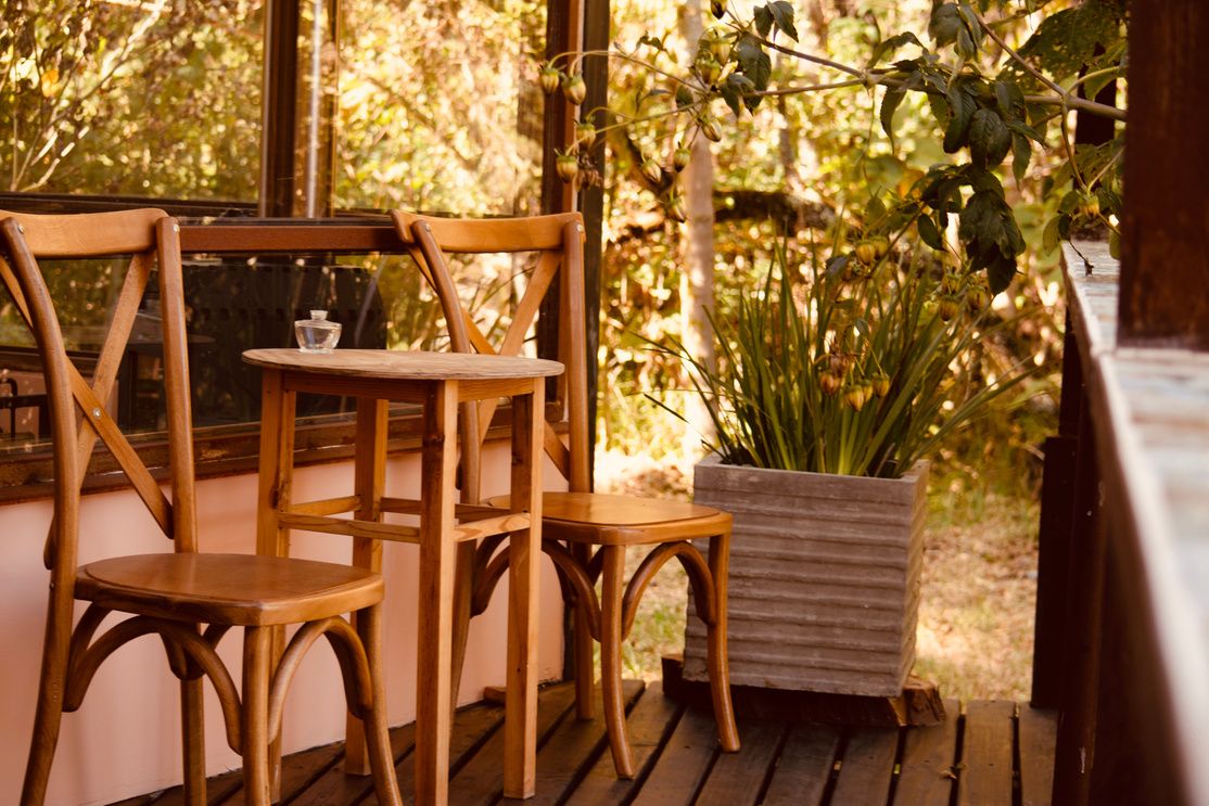 La terraza de madera con la mesa y las sillas