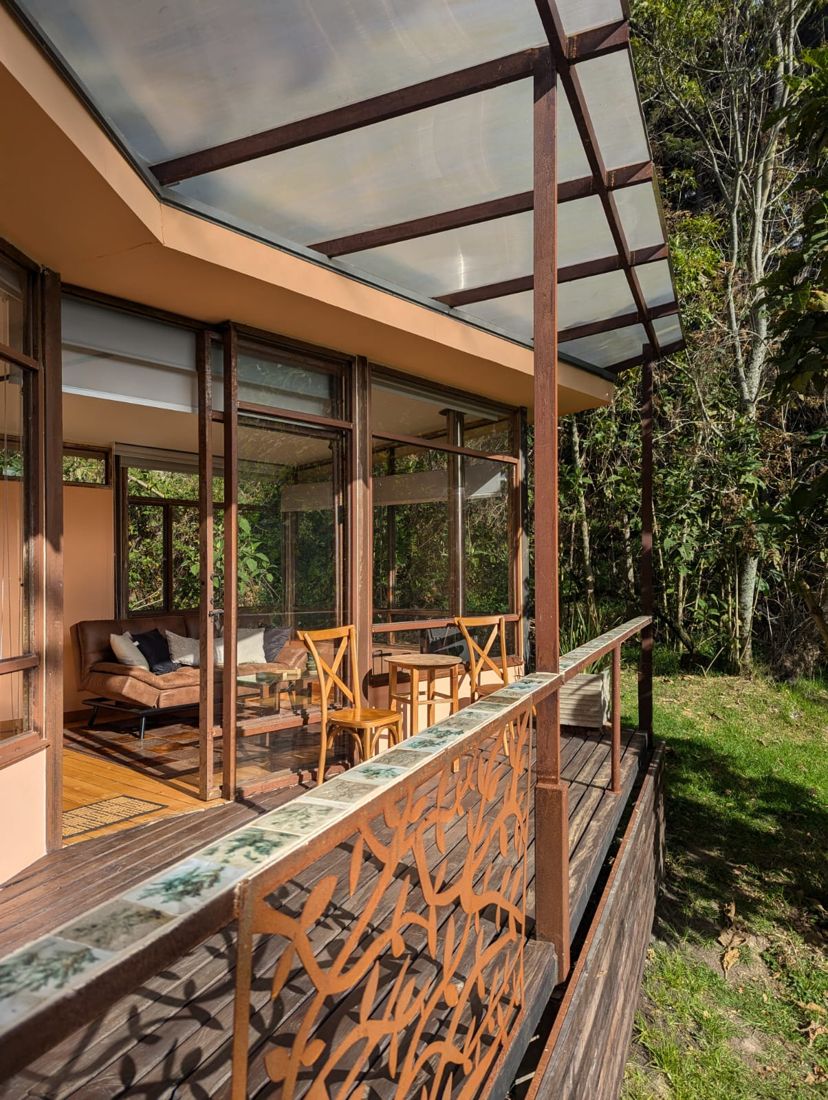 La cabaña vista desde el jardín, con la escalera de madera y las plantas